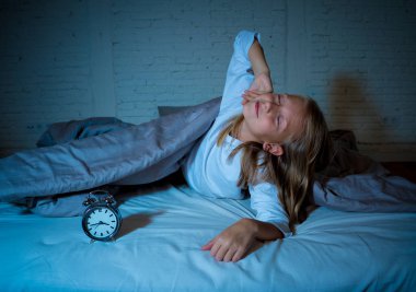Cute sleepless little girl in bed awake in the middle of the night looking tired having troubles staying asleep at night or waking up too early in Insomnia Anxiety Sleeping Disorders in children. clipart