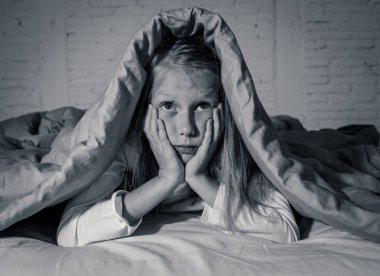 Sevimli küçük beyaz kız duygu yorgun ve uykusuz uykusuzluk depresyon stres çocuklar duygusal ve uyku bozuklukları kavram acı battaniye ile kafasını kapsayan yatakta yalan.