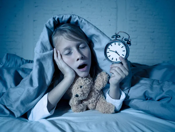 Симпатична Безсонна Дівчинка Лежить Ліжку Показуючи Будильник Який Виглядає Втомленим — стокове фото