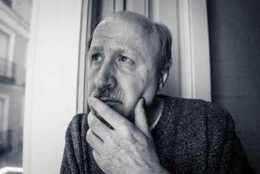 Üst düzey ihtiyar duygu pencereden bakan şaşkın ve yaşlanma emeklilik dul demans ve Alzheimer kavramı evde yalnız depresif.