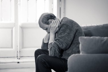 Kıdemli yaşlı adam umutsuz üzgün endişeli bakarak duygu düşünceli ve yalnız evde kanepede yaşlanma zihinsel sağlık kişisel sorunlar ve yaşam tarzı kavramı depresif.