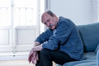 Kıdemli yaşlı adam umutsuz üzgün endişeli bakarak duygu düşünceli ve yalnız evde kanepede yaşlanma zihinsel sağlık kişisel sorunlar ve yaşam tarzı kavramı depresif.