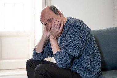 Bunalmış eski üst düzey adam yalnız ev hissi acı eskime emeklilik dul demans ve Alzheimer kavram evde kanepede yalnız üzücü şaşkın.