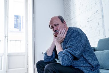 Bunalmış eski üst düzey adam yalnız ev hissi acı eskime emeklilik dul demans ve Alzheimer kavram evde kanepede yalnız üzücü şaşkın.