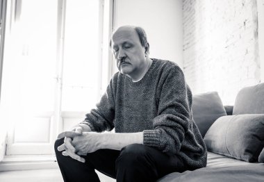 Kıdemli yaşlı adam umutsuz üzgün endişeli bakarak duygu düşünceli ve yalnız evde kanepede yaşlanma zihinsel sağlık kişisel sorunlar ve yaşam tarzı kavramı depresif.
