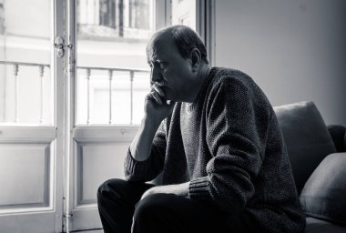 Kıdemli yaşlı adam umutsuz üzgün endişeli bakarak duygu düşünceli ve yalnız evde kanepede yaşlanma zihinsel sağlık kişisel sorunlar ve yaşam tarzı kavramı depresif.