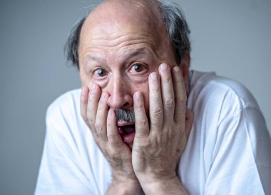 Korku içinde insan duygularını ifade ve yüz ifadeleri tarafsız arka planda izole korkmuş korkmuş yaşlı adam portresi kapatın.