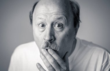 Korku içinde insan duygularını ifade ve yüz ifadeleri tarafsız arka planda izole korkmuş korkmuş yaşlı adam portresi kapatın.