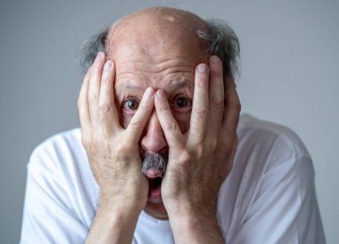 Korku içinde insan duygularını ifade ve yüz ifadeleri tarafsız arka planda izole korkmuş korkmuş yaşlı adam portresi kapatın.