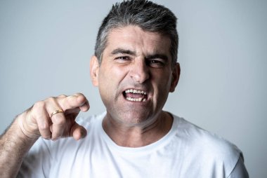 Bir öfkeli seyir olgun 40'lı 50'li beyaz kızgın ve üzgündüm ve agresif insan duyguları yüz ifadeleri ve duyguları kavramı üzerinde gri arka plan izole portresi.