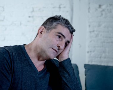 Çekici bir adam duygu umutsuz üzgün endişeli bakarak düşünceli ve yalnız orta yaş krizi ruhsal kişisel sorunlar ve yaşam tarzı kavramı evde kanepede depresyon acı depresif.