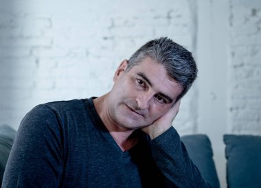 Çekici bir adam duygu umutsuz üzgün endişeli bakarak düşünceli ve yalnız orta yaş krizi ruhsal kişisel sorunlar ve yaşam tarzı kavramı evde kanepede depresyon acı depresif.