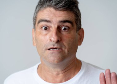 Portre bir 40'lı 50'li adam şokta korktuğunu ifade yüzünde insan duyguları duygu ve gri arka plan üzerinde izole yüz ifadesi kavramı korkmuş jestler yapma ile.