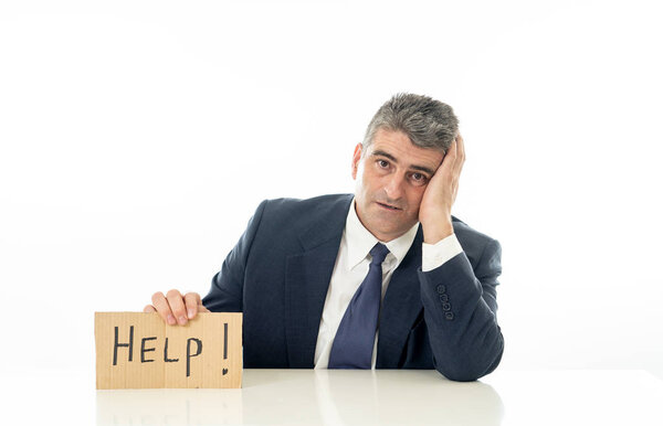 Helpless mature businessman holding a help sign in financial crisis unemployment stress and depression concept isolated in white background.
