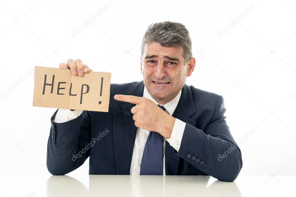 Helpless mature businessman holding a help sign in financial crisis unemployment stress and depression concept isolated in white background.