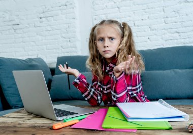 Sevimli İlköğretim öğrenci İlköğretim Okulu ödev ve çocuk eğitim kavramı evde onu laptop ile zor atama yaparken duygu üzgün ve kafa karıştırıcı.