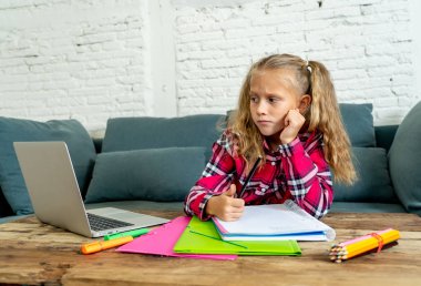 Sevimli İlköğretim öğrenci İlköğretim Okulu ödev ve çocuk eğitim kavramı evde onu laptop ile zor atama yaparken duygu üzgün ve kafa karıştırıcı.