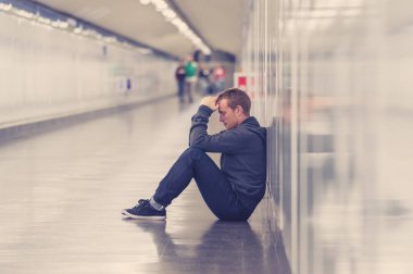 Sefil işsiz genç adam ağlayan uyuşturucu bağımlısı evsizlere depresyon stres zemin sokak Metro'ya ruhsal bozukluk duygusal acı üzüntü yalnız duvara yaslanmış umutsuz seyir üzerinde oturan.