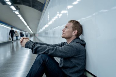 Sefil işsiz genç adam ağlayan uyuşturucu bağımlısı evsizlere depresyon stres zemin sokak Metro'ya ruhsal bozukluk duygusal acı üzüntü yalnız duvara yaslanmış umutsuz seyir üzerinde oturan.