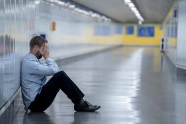 Genç işsiz iş adam oturan depresyon acı duvar yalnız duygusal acı ruh sağlığı işsizlik ve insan duyguları kavramı umutsuz seyir üzerinde Sokak Metro yaslanmış zemin.
