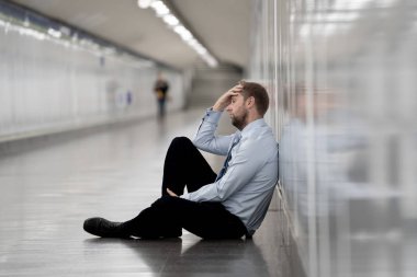 Genç işsiz iş adam oturan depresyon acı duvar yalnız duygusal acı ruh sağlığı işsizlik ve insan duyguları kavramı umutsuz seyir üzerinde Sokak Metro yaslanmış zemin.