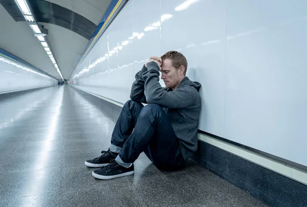 失業青年泣いている麻薬中毒悲惨なうつ病のホームレス ストレス精神障害感情的な痛み悲しみで一人で壁にもたれて必死に探して地上通り地下鉄トンネルの上に座って — ストック写真