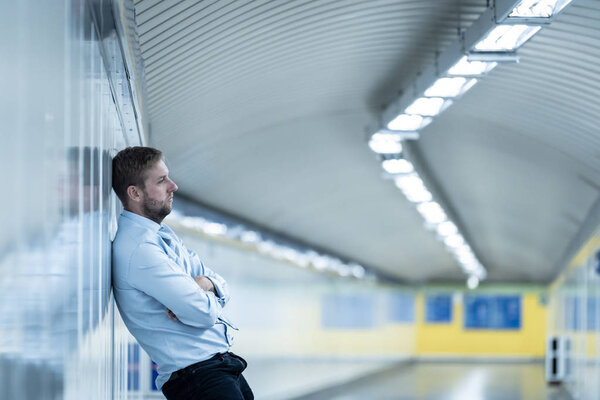 Young jobless business man suffering depression leaning on street underground wall alone looking desperate in Emotional pain Mental health Unemployment Human emotions and sadness concept.