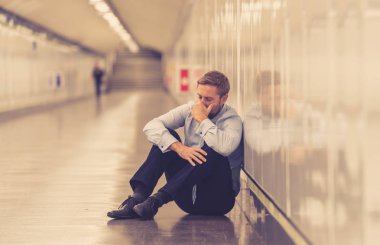 Genç işsiz iş adam oturan depresyon acı duvar yalnız duygusal acı ruh sağlığı işsizlik ve insan duyguları kavramı umutsuz seyir üzerinde Sokak Metro yaslanmış zemin.