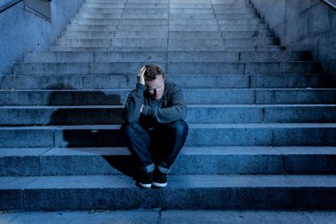 Lost ın depresyon zemin beton merdiven duygusal acı yalnızlık üzüntü zihinsel sağlık kavramı grunge aydınlatmada yalnız oturan genç umutsuz işsiz adam rahat kıyafetler içinde terk.
