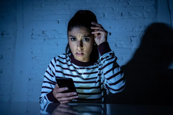 害怕的青少年或年轻的妇女使用智能手机作为互联网网络欺凌的消息跟踪被虐待的受害者 — 图库照片