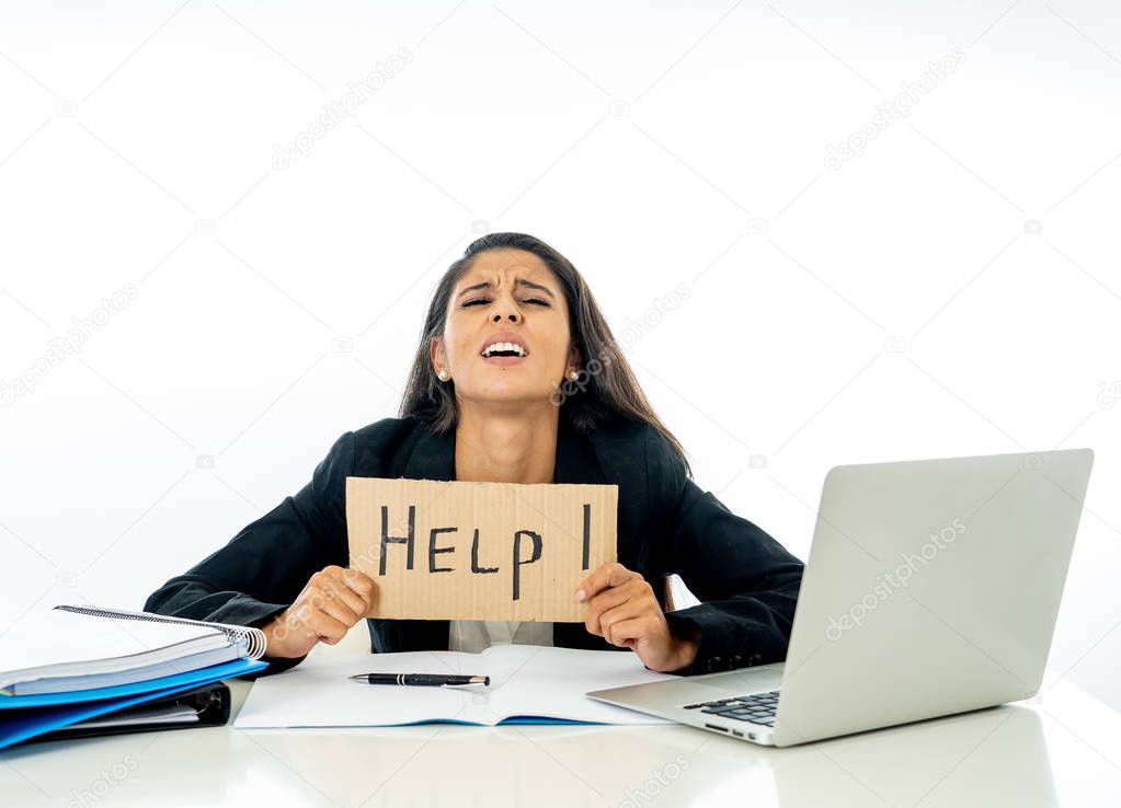Young attractive businesswoman working on computer laptop suffering stress at office going crazy holding a help sign