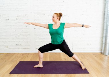 Genç çekici Yoga öğretmeni savaşçı iki egzersiz Fitness çalışma Virabhadrasana II poz Yoga Faydaları ve zihinsel duygusal ve fiziksel kavram olmanın iyi dışarı ayakta pratik portresi.