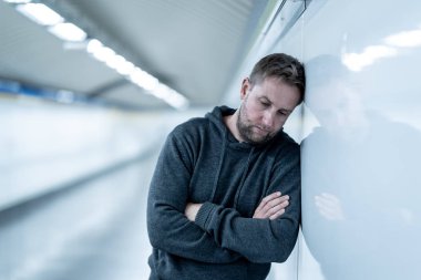 Üzgün işsiz genç adam ağlayan acı depresyon stres zemin sokak Metro'ya eğilerek duvar ruhsal bozukluk duygusal acı uyuşturucu yalnız ve alkolizm umutsuz seyir üzerinde oturan.
