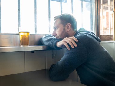 Bir barda bira içme çekici bir adam portresi pub duygu depresif mutsuz ve yalnız alkol kullanım istismarı depresyon ve ruh sağlığı kavramı.