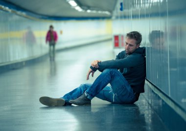 Üzgün genç adam ağlayan acı depresyon stres zemin sokak Metro'ya eğilerek duvar ruhsal bozukluk duygusal ağrı bağımlılığı yalnız ve işsizlik kavramı üzerinde umutsuz seyir üzerinde oturan.