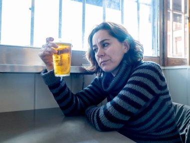 Bir barda bira içme çekici bir latin kadın portresi pub duygu depresif mutsuz ve yalnız alkol kullanım istismarı depresyon ve ruh sağlığı kavramı.