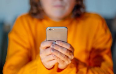 Online oynarken ve metin renkli bir arka plan ile akıllı telefon üzerinden ekran telefon bağımlılığı Internet oyun bağlantısı ve yeni teknoloji ışık göndererek genç veya yetişkin kadın kapatmak.