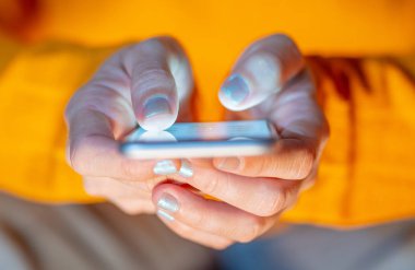 Online oynarken ve metin renkli bir arka plan ile akıllı telefon üzerinden ekran telefon bağımlılığı Internet oyun bağlantısı ve yeni teknoloji ışık göndererek genç veya yetişkin kadın kapatmak.