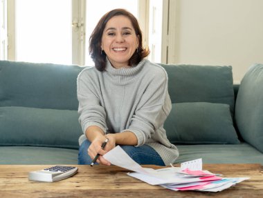 Kredi kartı ve hesap makinesi muhasebe ücreti, genç çekici latin iş kadın ücretleri, vergi ve evde kanepe üzerinde ipotek mutlu ve kendi iş başarısı ile rahat seyir fatura ödeme
