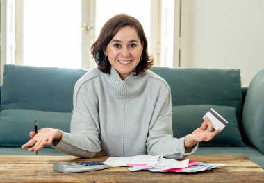 Kredi kartı ve hesap makinesi muhasebe ücreti, genç çekici latin iş kadın ücretleri, vergi ve evde kanepe üzerinde ipotek mutlu ve kendi iş başarısı ile rahat seyir fatura ödeme