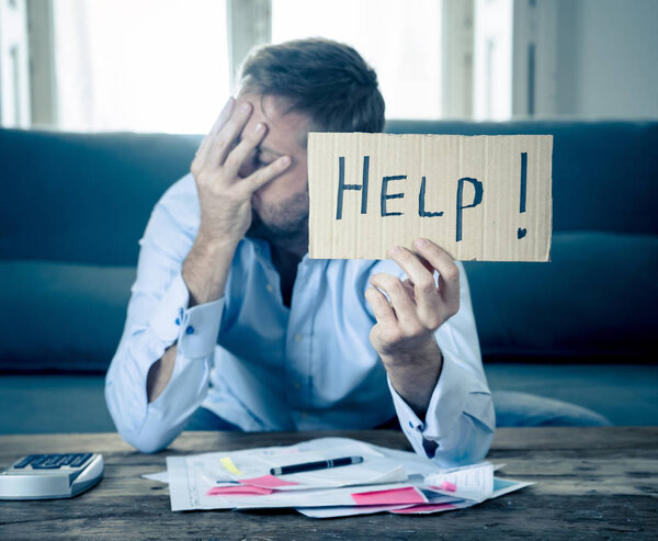 Worried and desperate business man asking for help in paying off debts and loan calculating bills tax expenses and accounting finances sitting on couch in paying bills and Financial problems concept.