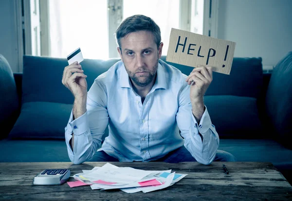 Worried and desperate business man asking for help in paying off debts and loan calculating bills tax expenses and accounting finances sitting on couch in paying bills and Financial problems concept.