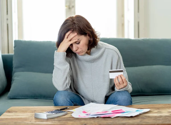 Young attractive woman looking stressed and worried with card payments and home finances accounting costs charges taxes and mortgage in paying bills financial problems and credit card debts concept.