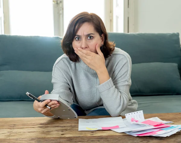 Young attractive woman looking stressed and worried with card payments and home finances accounting costs charges taxes and mortgage in paying bills financial problems and credit card debts concept.