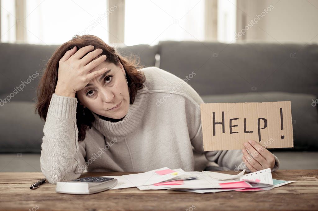 Worried and desperate woman asking for help in paying off debts and loan calculating bills tax expenses and accounting home finances sitting on couch in Domestic bills and Financial problems concept.