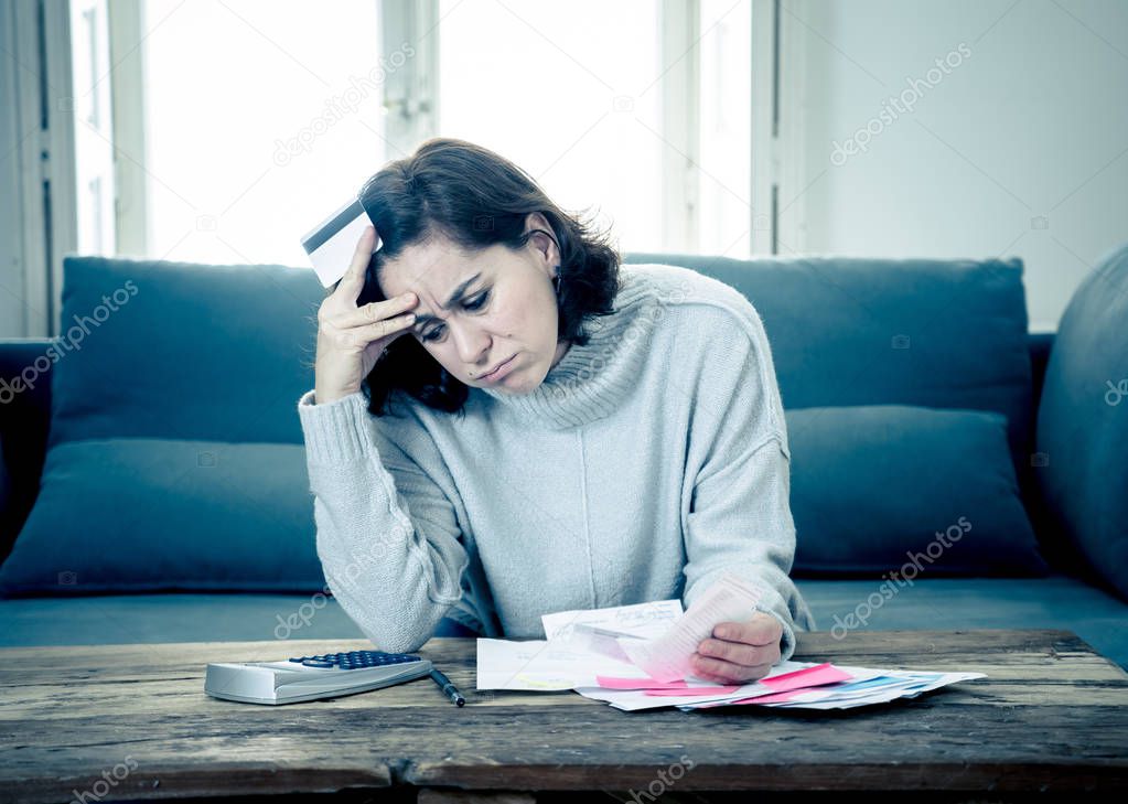 Young attractive woman looking stressed and worried with card payments and home finances accounting costs charges taxes and mortgage in paying bills financial problems and credit card debts concept.