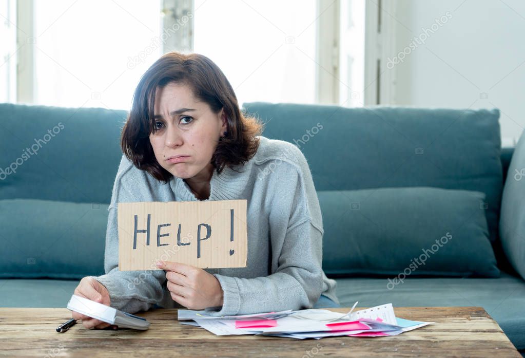 Worried and desperate woman asking for help in paying off debts and loan calculating bills tax expenses and accounting home finances sitting on couch in Domestic bills and Financial problems concept.
