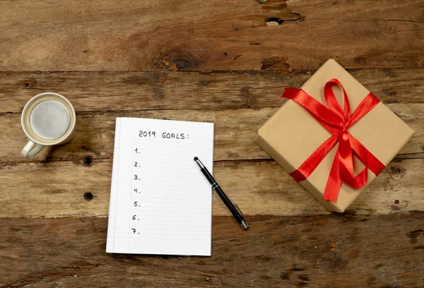 Top View 2019 Goals list on notepad coffee and gift box on Vintage Background for wishes to achieve in better life in New Years resolution and Goals for happiness Aspiration and Motivation Concept.