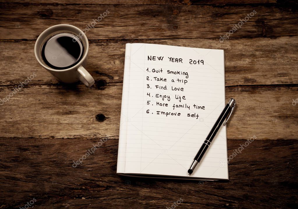 Top View 2019 New year list with resolutions and wishes for new life written on notepad coffee and pen on Vintage table background in dreams and Goals for happiness Aspiration and Motivation Concept.