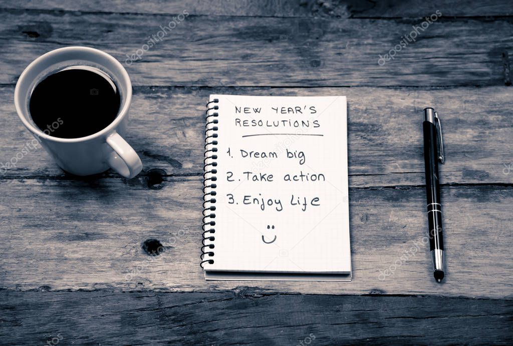 Top View 2019 New year resolutions list with plans for new life happy face written on notepad coffee and pen on Vintage table in Dreams and Goals for happiness Aspiration and Motivation Concept.